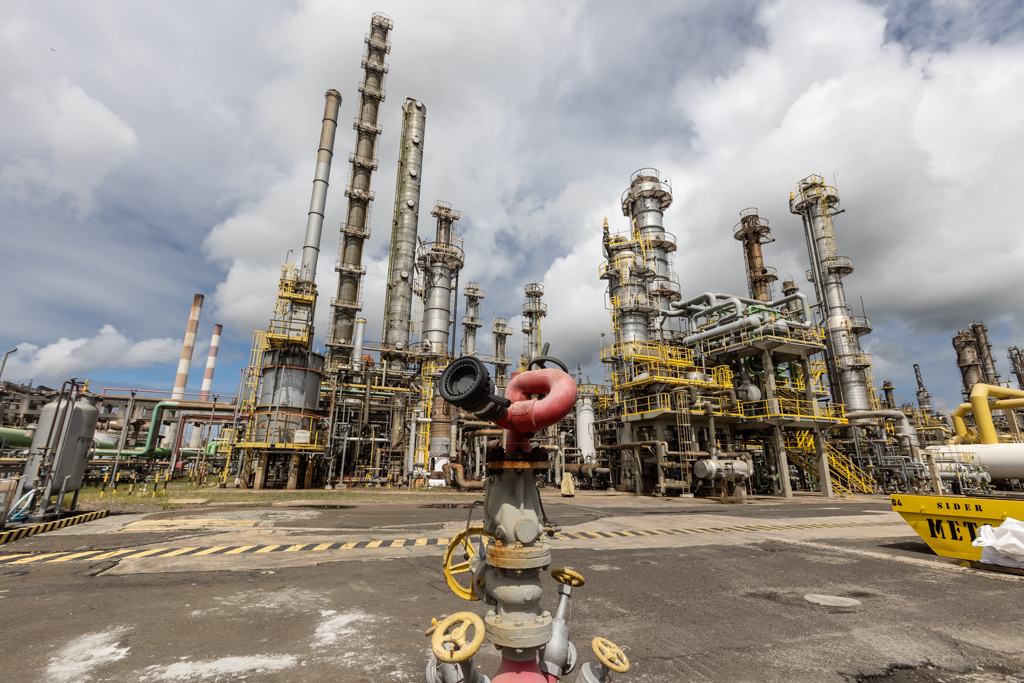 Polo Industrial de Camaçari, tendo como fundo o céu azul com nuvens.