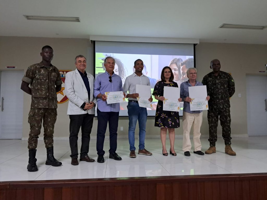 Edneide Lima, superintendente do IEL, representantes do Sistema FIEB e do Exército juntos em um auditório, segurando certificados.